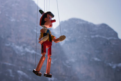 Low angle view of red standing on mountain against sky