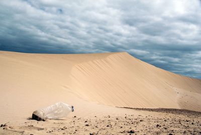 Sand dunes in desert against sky