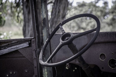 Close-up of bicycle wheel against trees