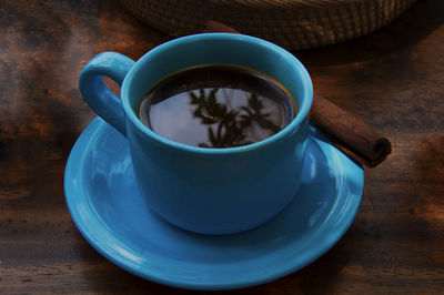 High angle view of cinnamon coffee in blue cup on table