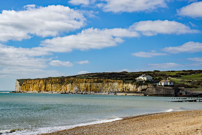 Scenic view of beach by sea against sky