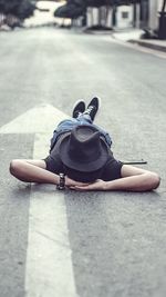 Rear view of man sitting on road