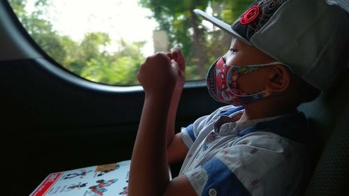 Rear view of boy sitting in car