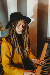 Young woman wearing hat sitting on stage