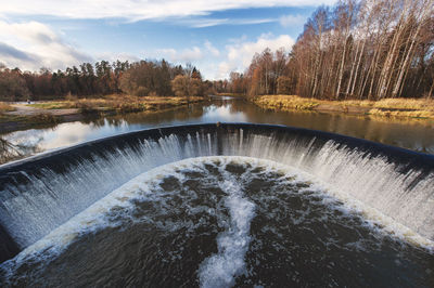 Scenic view of river flowing amidst dam