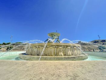Scenic view of triton fountain against clear blue sky