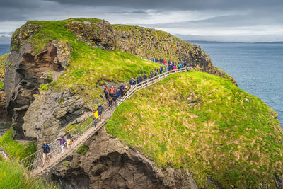 Group of people crossing carrick a rede rope bridge, northern ireland