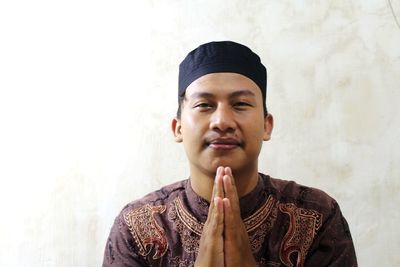 A man in a muslim dress pose apologizing