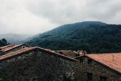 Scenic view of houses and mountains against sky