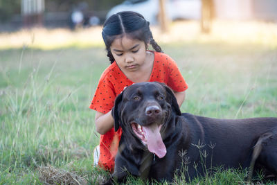 Cute girl with dog on field