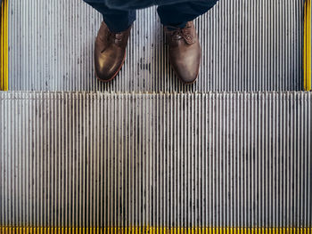 Low section of man standing on tiled floor