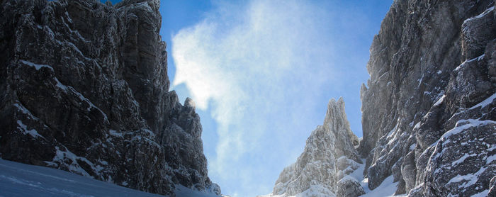 Low angle view of snowcapped mountains against sky