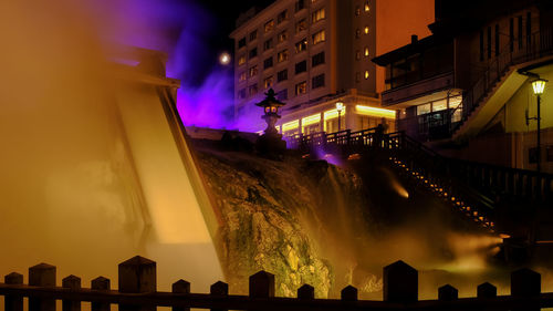 Low angle view of illuminated buildings against sky at night