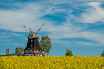 Traditional windmill on field against sky