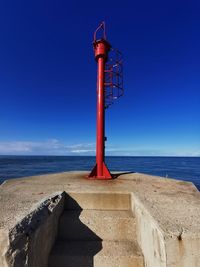 Lighthouse by sea against sky