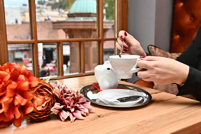 Close-up of hand with pink flowers on table