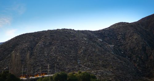 Low angle view of mountains against clear blue sky