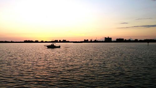 Boat sailing in sea at sunset