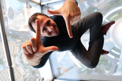 High angle view of man sitting on glass floor