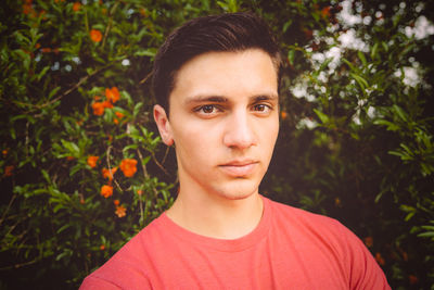 Portrait of handsome man standing against trees