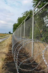 Fence on field against sky