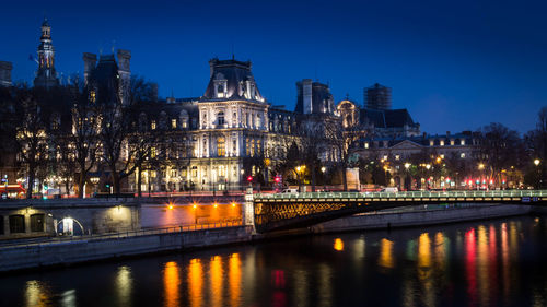 Parisian landscape near the hotel de ville in paris with the seine river at night