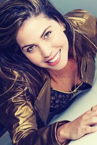 Directly above portrait of smiling beautiful woman standing by wall