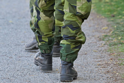 Low section of army soldiers walking on road