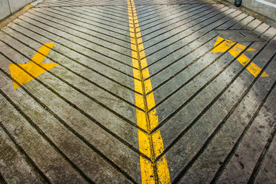Close-up of yellow arrow sign on parking ramp