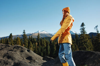 Rear view of woman standing on rock