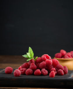 Ripe red raspberries on a brown wooden board