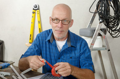 Portrait of plumber working at workbench