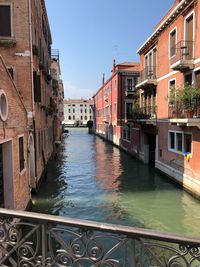 Canal amidst buildings against sky
