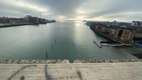 High angle view of river by buildings against sky