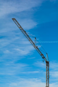 Low angle view of crane against sky