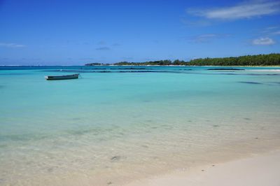 Scenic view of beach against blue sky