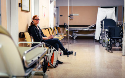 Mid adult women sitting on chair at hospital
