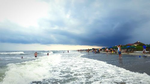People on beach against sky