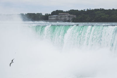 Scenic view of waterfall against sky