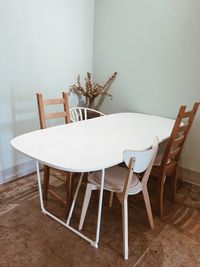 Empty chairs and table against wall at home