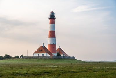 Lighthouse by sea against sky