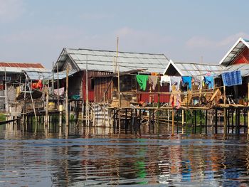 Houses by lake against sky