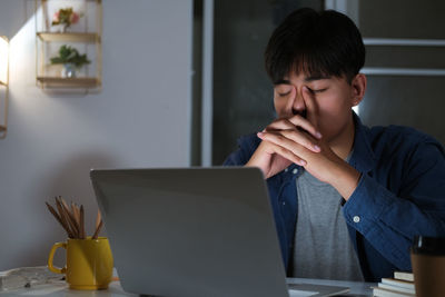 Boy looking away while sitting on table