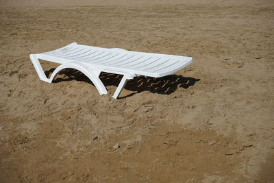 High angle view of empty chairs on sand at beach