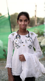 Portrait of smiling young woman standing on field