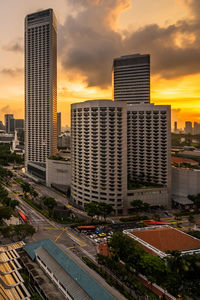 Modern buildings in city against sky during sunset