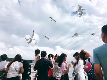 Group of people on birds against sky