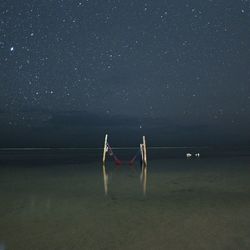 Scenic view of lake against star field in sky at night