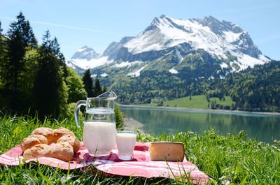 Scenic view of lake and snowcapped mountains against sky