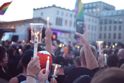 People holding candles on street in city during homage